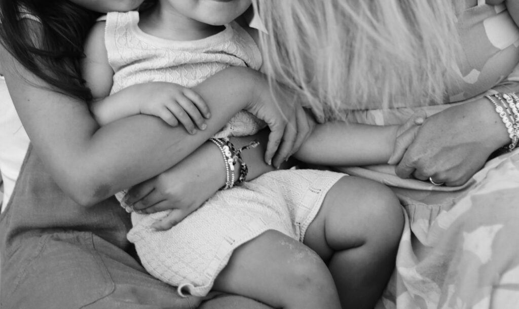 up close black and white family photograph of a mother and her two daughters with hands intertwined and lots of jewelry -bisoux de lune meagan reily