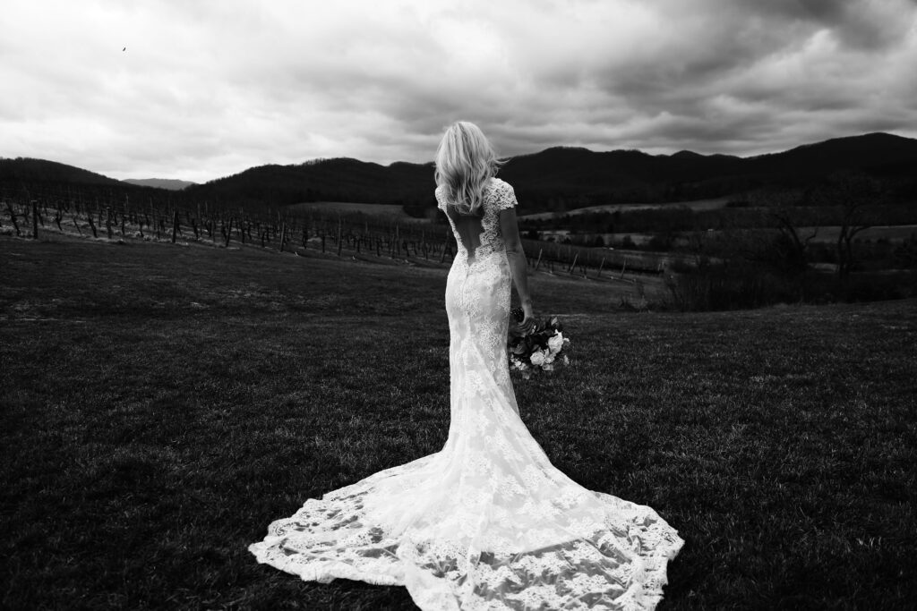 gorgeous black and white photograph of a bride overlooking the rolling hills of the shenandoah mountains with clouds in the background -bisoux de lune meagan reily