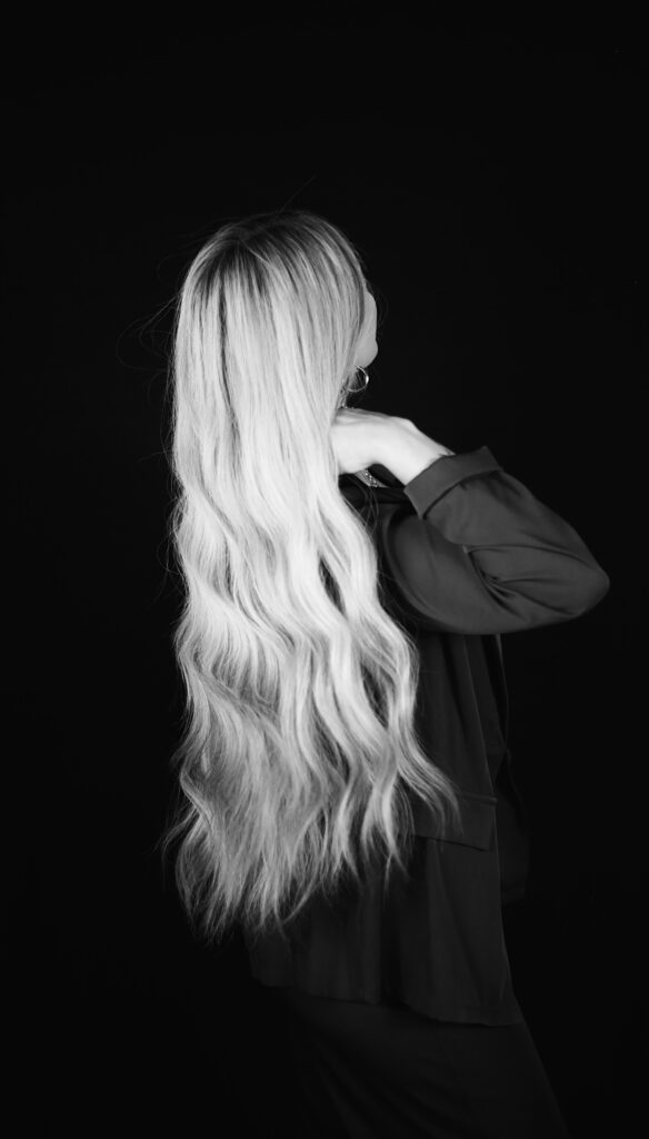 blonde model in a business suit with long blonde extentions black backdrop vogue -bisoux de lune meagan reily