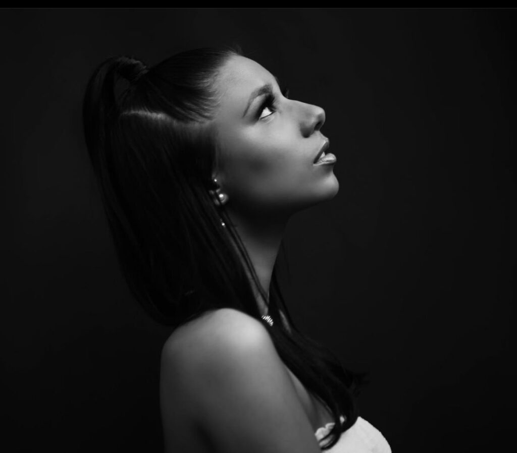 high contrast portait of an african american mixed woman looking up at the sky with glamourous make up and a black backdrop - bisoux de lune meagan reily